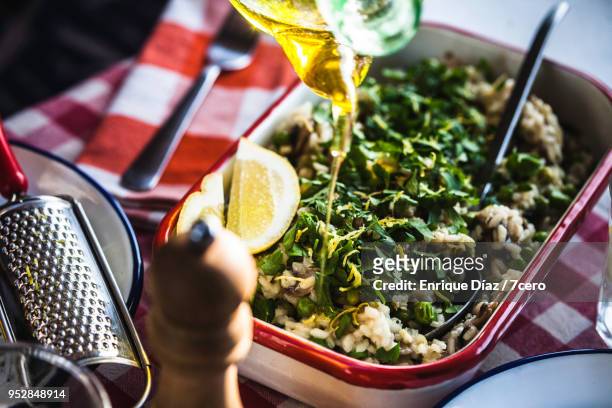 mushroom, pea and lemon risotto, adding olive oil - italian parsley stock pictures, royalty-free photos & images