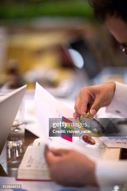 using a magnifying glass - regulatory scrutiny stock pictures, royalty-free photos & images