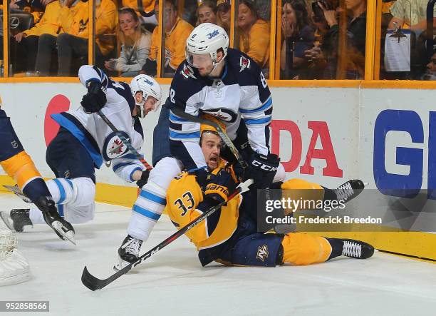 Jacob Trouba of the Winnipeg Jets holds down Viktor Arvidsson of the Nashville Predators during the first period in Game Two of the Western...