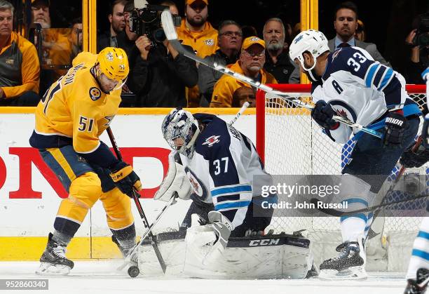 Connor Hellebuyck of the Winnipeg Jets makes the save against Austin Watson of the Nashville Predators in Game Two of the Western Conference Second...