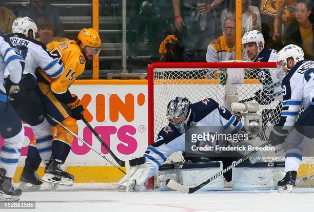 Craig Smith of the Nashville Predators tries a wrap-around shot on goalie Connor Hellebuyck of the Winnipeg Jets during the second period in Game Two...