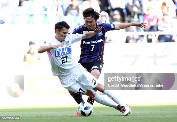 Ryosuke Tagawa of Sagan Tosu and Yasuhito Endo of Gamba Osaka compete for the ball during the J.League J1 match between Gamba Osaka and Sagan Tosu at...