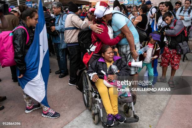 Central American migrants traveling in the "Migrant Via Crucis" caravan say goodbye to their relatives, before entering El Chaparral border crossing...