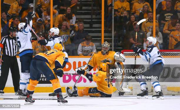 Austin Watson, P.K. Subban and Pekka Rinne of the Nashville Predators watch as Mark Scheifele of the Winnipeg Jets is congratulated by teammate Paul...