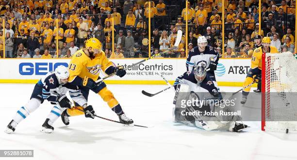 Connor Hellebuyck of the Winnipeg Jets makes the save against Nick Bonino of the Nashville Predators as Josh Morrissey defends in Game Two of the...