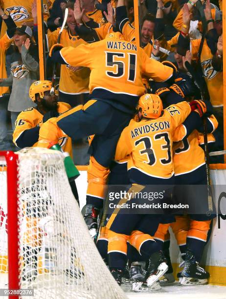 Austin Watson of the Nashville Predators jumps on top of teammate Viktor Arvidsson and other teammates after defeating the Winnipeg Jets during the...