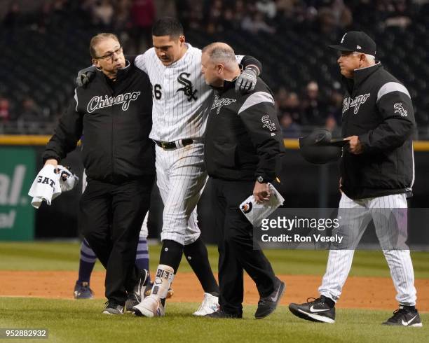 Avisail Garcia of the Chicago White Sox is helped off the field by Head Trainer Herm Schneider and Assistant Trainer Brian Ball while manger Rick...