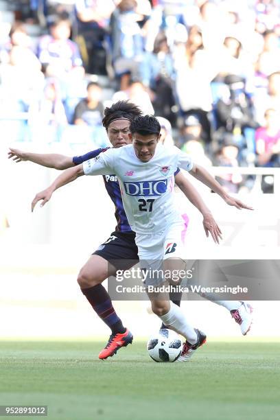 Ryosuke Tagawa of Sagan Tosu and Yasuhito Endo of Gamba Osaka compete for the ball during the J.League J1 match between Gamba Osaka and Sagan Tosu at...