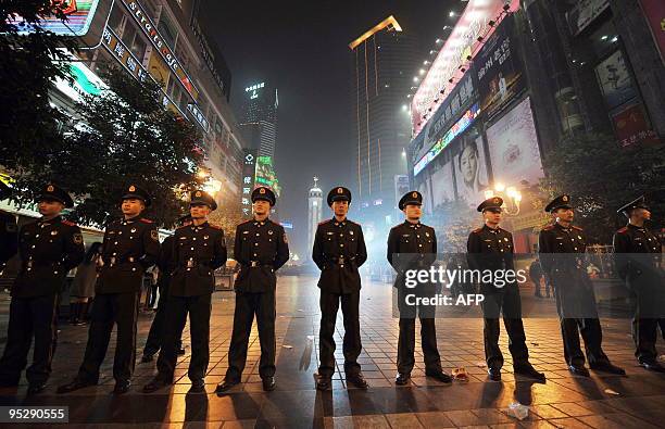 Chinese police stand guard as thousands gather to celebrate Chirstmas Eve at the centre of southwest China's Chongqing municipality on December 24,...