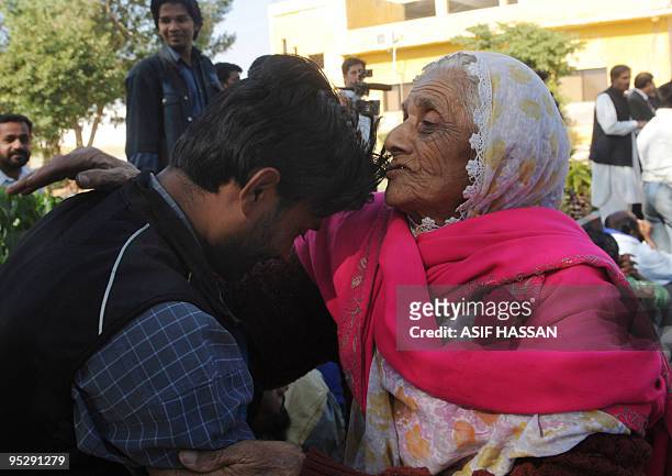 Elderly Pakistani woman kisses the forehead of an Indian fisherman before boarding a bus in Karachi on December 25, 2009. Pakistan has released 100...