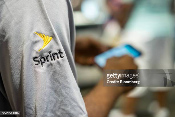 Sprint Corp. Employee uses a smartphone inside the James R. Thompson Center in Chicago, Illinois, U.S., on Friday, July 22, 2016. T-Mobile US Inc....