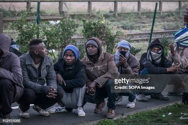 Refugees and migrants wait in line to leave the Calais Jungle. The Jungle was an illegal migrant camp in the northern French town of Calais. The camp...