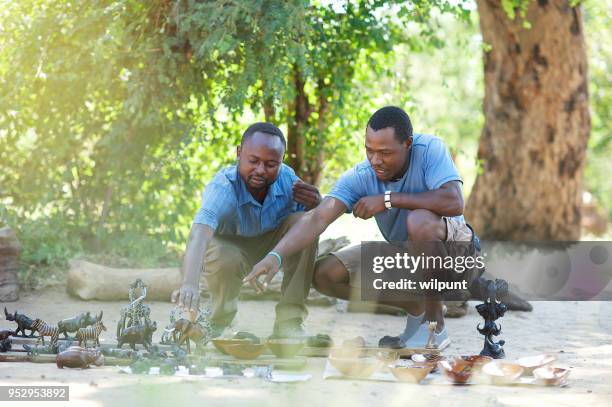 two men negotiating over african merchandise - zimbabwe stock pictures, royalty-free photos & images