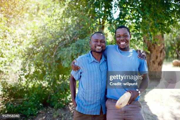 business vrienden permanent samen onder een boom - zimbabwe stockfoto's en -beelden