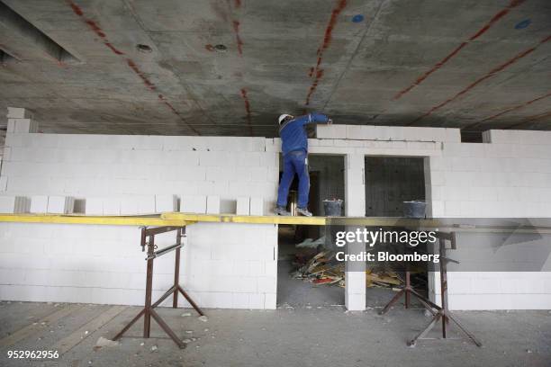 Bricklayer works on an apartment wall as building work continues on the Omiturm mixed-use 45-story residential and office tower block, developed by...