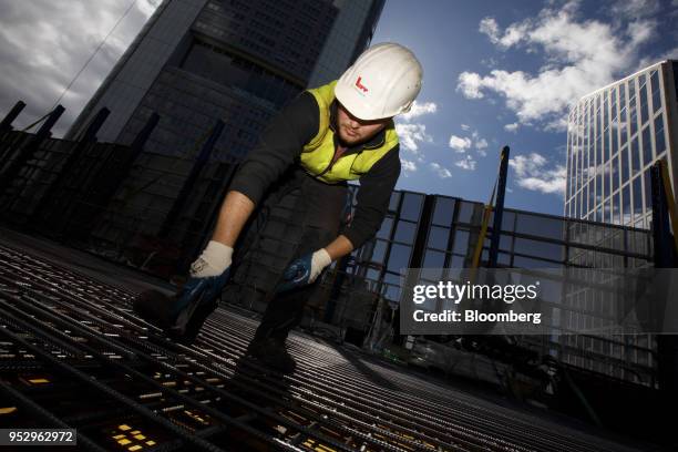 Construction worker secures steel reinforcement rods as building work continues on the Omiturm mixed-use 45-story residential and office tower block,...