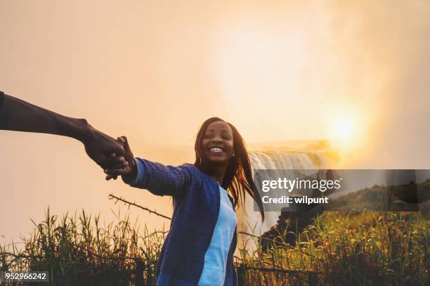 mirada y las manos tirando hacia cataratas victoria - zimbabue fotografías e imágenes de stock