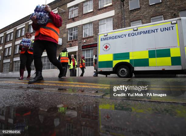 Volunteers carry provisions from an emergency equipment unit van, during an emergency simulation with an extreme snow scenario by the British Red...