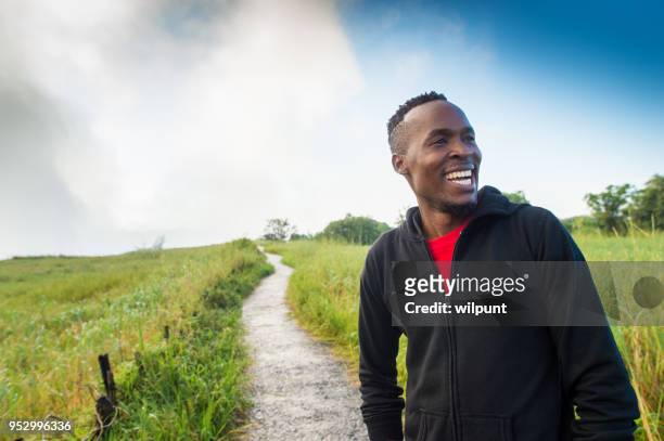 african man standing at a footpath looking away laughing - zimbabwe stock pictures, royalty-free photos & images