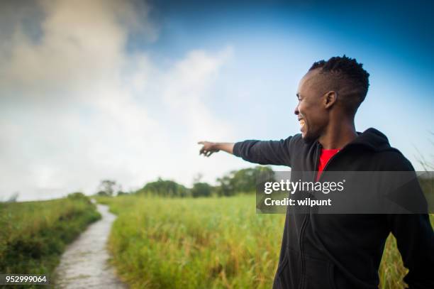 side view african man standing at a footpath pointing - victoria falls sunset stock pictures, royalty-free photos & images