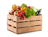 Fruits and vegetables in a wooden crate on white background