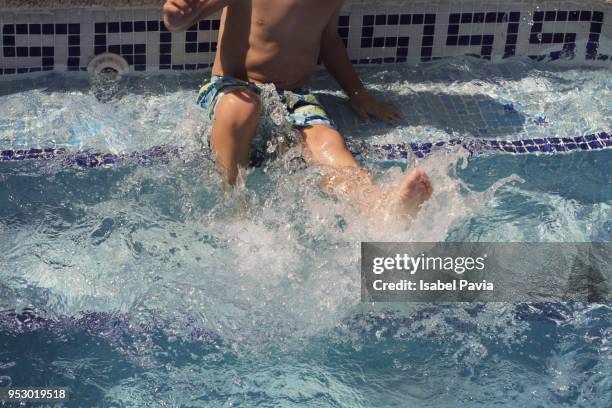 boy splashing in pool - isabel pavia stock pictures, royalty-free photos & images