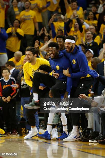 Players on the Golden State Warriors bench react to a basket made by teammate Klay Thompson of the Golden State Warriors during Game One of the...