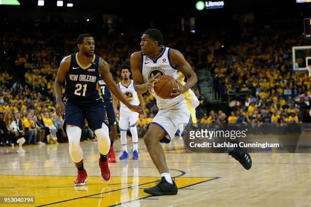 Kevon Looney of the Golden State Warriors drives to the basket against Darius Miller of the New Orleans Pelicans during Game One of the Western...
