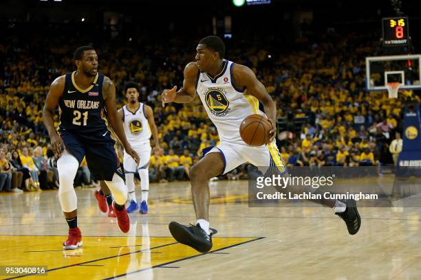 Kevon Looney of the Golden State Warriors drives to the basket against Darius Miller of the New Orleans Pelicans during Game One of the Western...