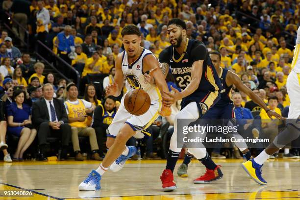 Klay Thompson of the Golden State Warriors competes for a loose ball against Anthony Davis of the New Orleans Pelicans during Game One of the Western...