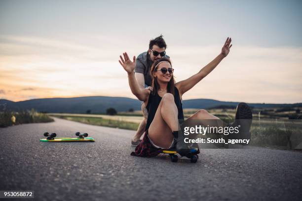 beautiful couple having fun skateboarding - extreme skating stock pictures, royalty-free photos & images