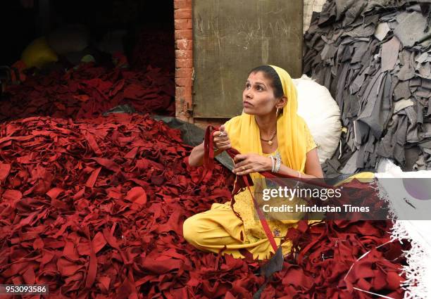 Woman shreds clothes with special slicers, on April 19, 2018 in Panipat, India. The piles of clothes have already been sorted into the basic colour...