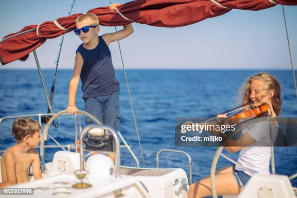 teenage girl playing violin on yacht - kavalla stock pictures, royalty-free photos & images