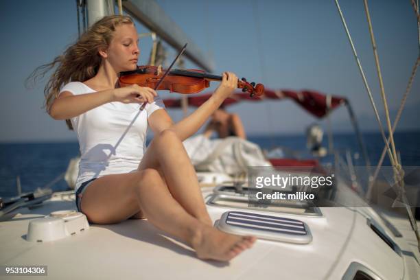 teenage girl playing violin on yacht - kavalla stock pictures, royalty-free photos & images