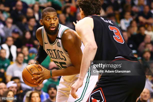 Greg Monroe of the Boston Celtics dribbles the ball while guided by Omer Asik of the Chicago Bulls during a game at TD Garden on April 6, 2018 in...