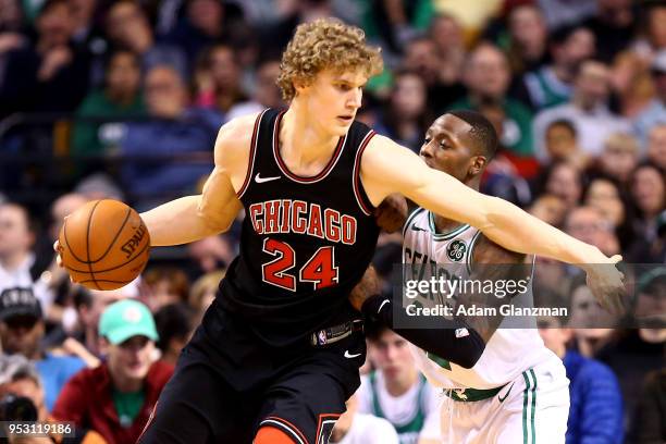 Lauri Markkanen of the Chicago Bulls is guarded by Terry Rozier of the Boston Celtics during a game at TD Garden on April 6, 2018 in Boston,...