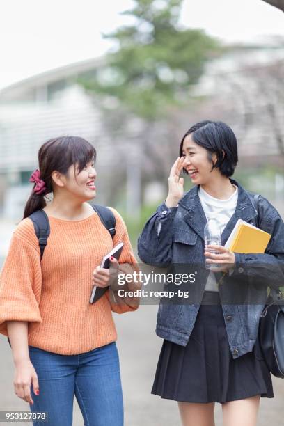 twee vrouwtjes studenten lopen naar les - japanese short skirts stockfoto's en -beelden