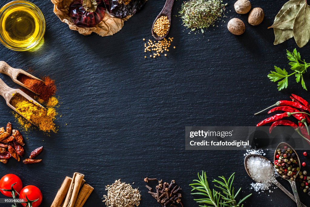 Cooking nd seasoning spices border on black slate background