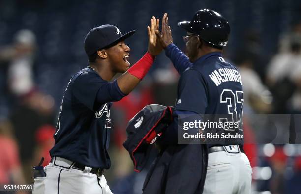 Ronald Acuna Jr. #13 and third base coach Ron Washington of the Atlanta Braves congratulate each other after defeating the Philadelphia Phillies 4-1...