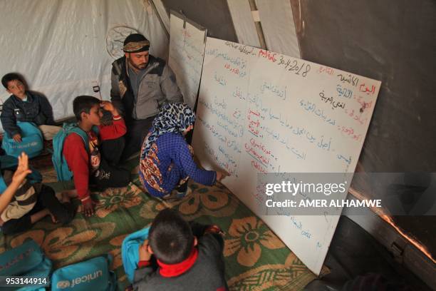 Picture taken on April 30, 2018 in a camp for displaced Syrians from villages and towns around Abu Duhur on the eastern edge of Idlib province, shows...