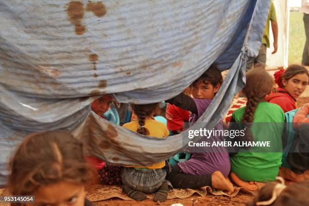 Picture taken on April 30, 2018 in a camp for displaced Syrians from villages and towns around Abu Duhur on the eastern edge of Idlib province, shows...