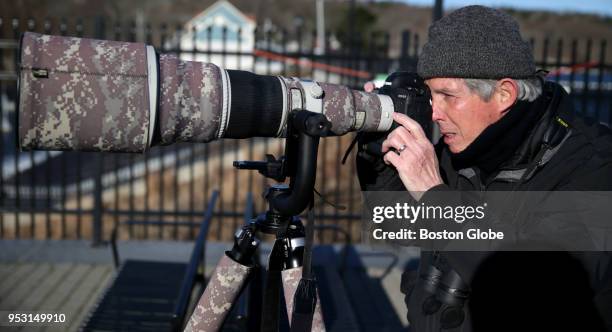 Jim Renault looks to get a photograph of a bald eagle as it flies above the Mystic Lakes in Medford, MA on March 31, 2018. The Mystic Lakes, which...
