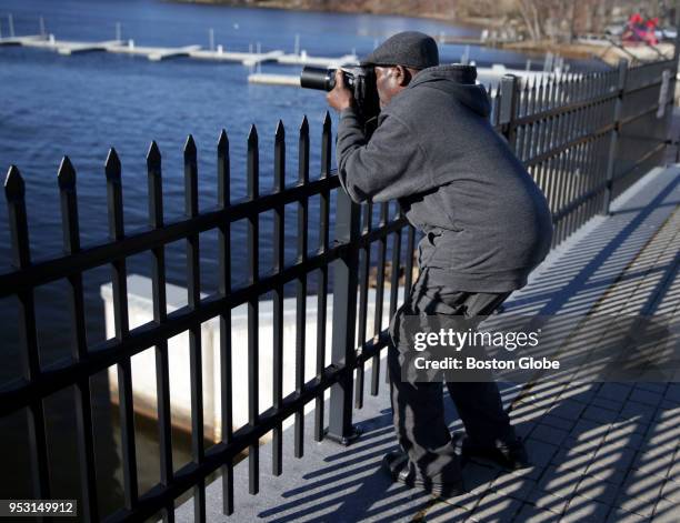 Bill Caines looks to get a photograph of a bald eagle as it flies above the Mystic Lakes in Medford, MA on March 31, 2018. The Mystic Lakes, which...