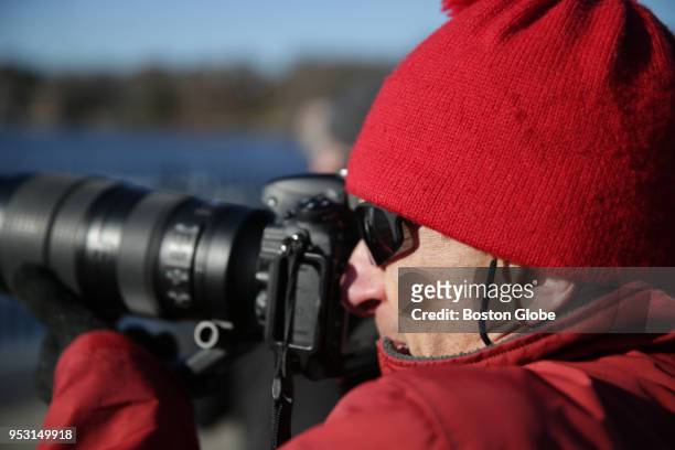 Ken Stampfer looks to get a photograph of a bald eagle as it flies above the Mystic Lakes in Medford, MA on March 31, 2018. The Mystic Lakes, which...