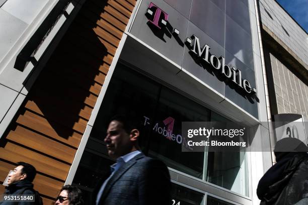 Pedestrians pass in front of a T-Mobile US Inc. Store in New York, U.S. On Monday, April 30, 2018. Sprint Corp. Suffered its worst stock decline in...