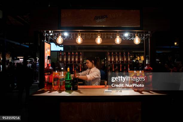 Young woman working in the Aperol booth inside the market of San Miguel in Madrid, Spain, on 29 April, 2018. On weekends the city of Madrid offers a...