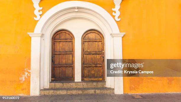 colorful facade and doors to old colonial house in antigua, guatemala - ruina antigua stock pictures, royalty-free photos & images