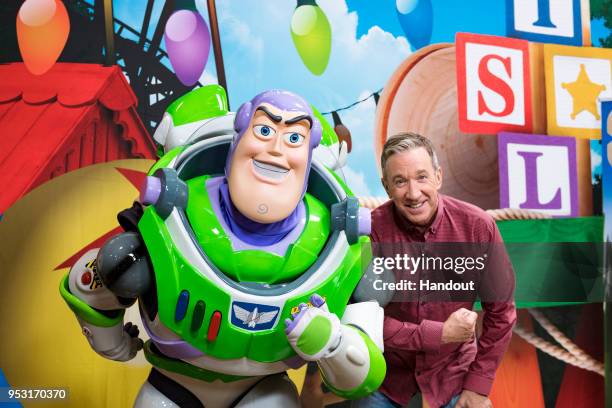 In this handout photo provided by Disney Parks, Tim Allen strikes a pose with Buzz Lightyear after taping an interview for Toy Story Land-exclusive...