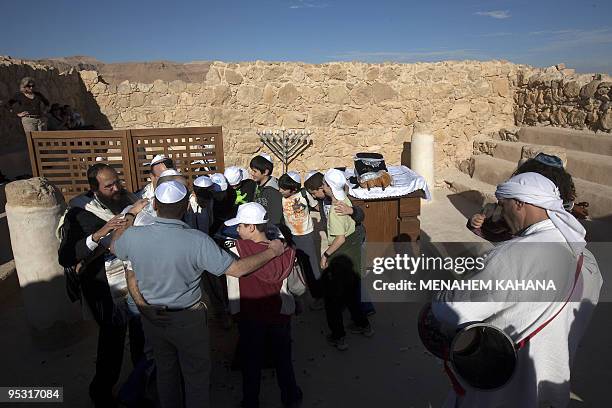 Jewish family dances during a Bar Mitzvah ceremony in the ancient synagogue of the hilltop fortress of Masada in the Judean desert on December 21,...
