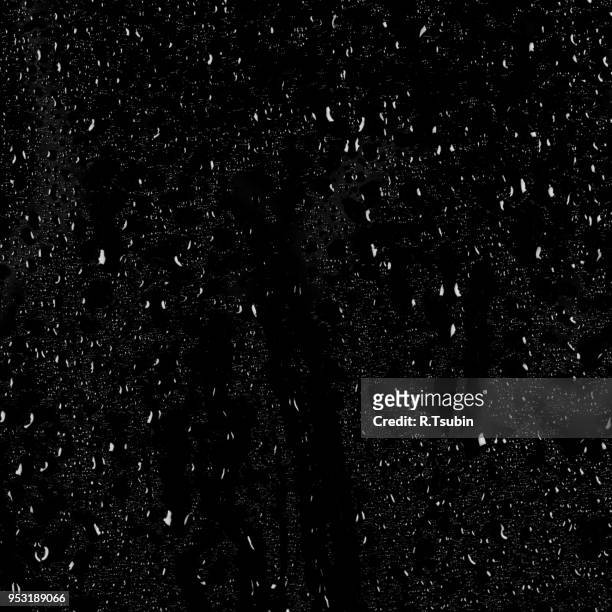 drops of water on a dark glass texture background - gota de lluvia fotografías e imágenes de stock